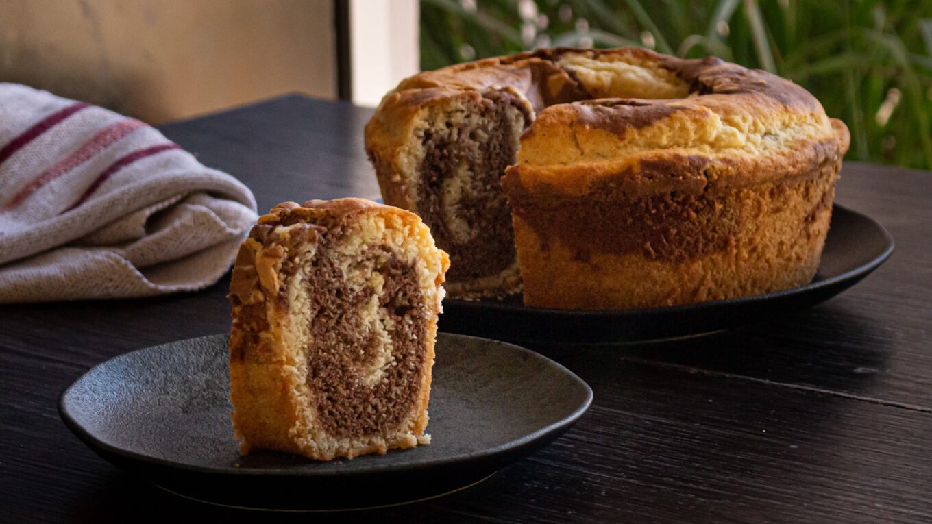 bolo mármore e um prato com uma fatia do bolo mostrando o marmorizado das duas cores de massa