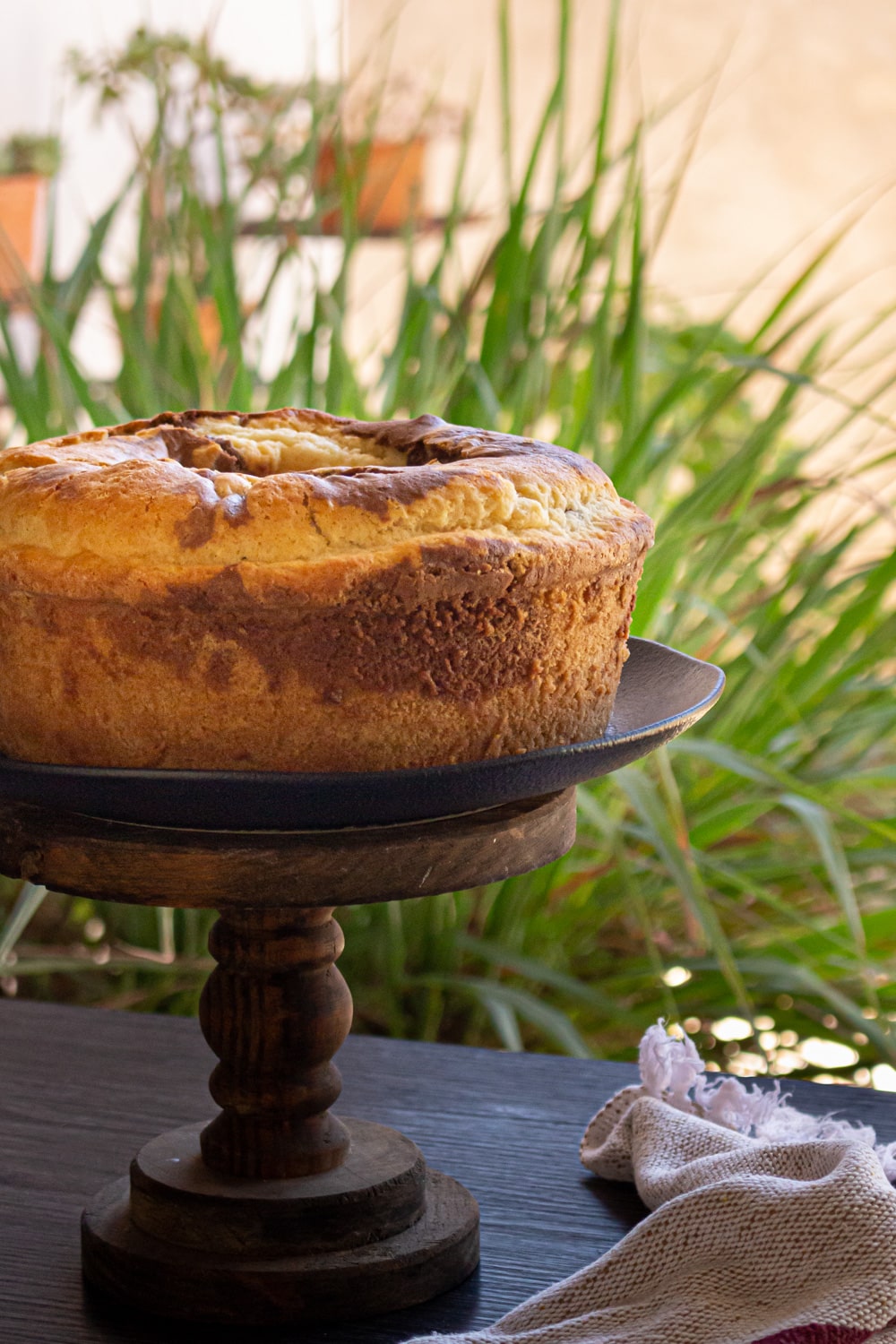 bolo redondo em um prato alto de madeira