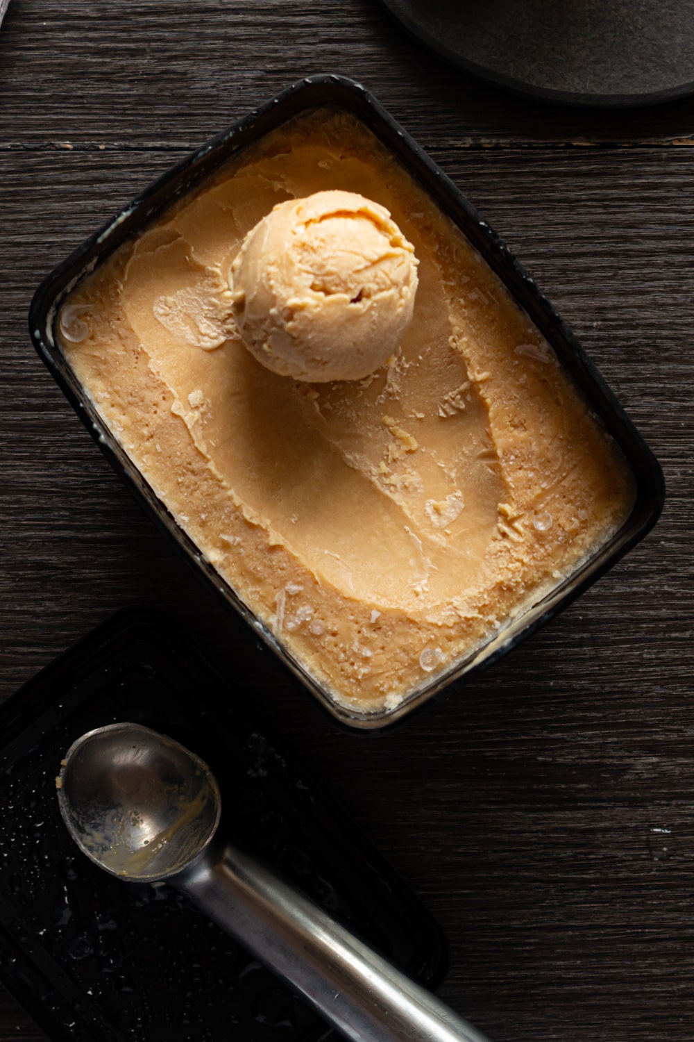 pote com sorvete de caramelo e uma bola de sorvete formada no topo