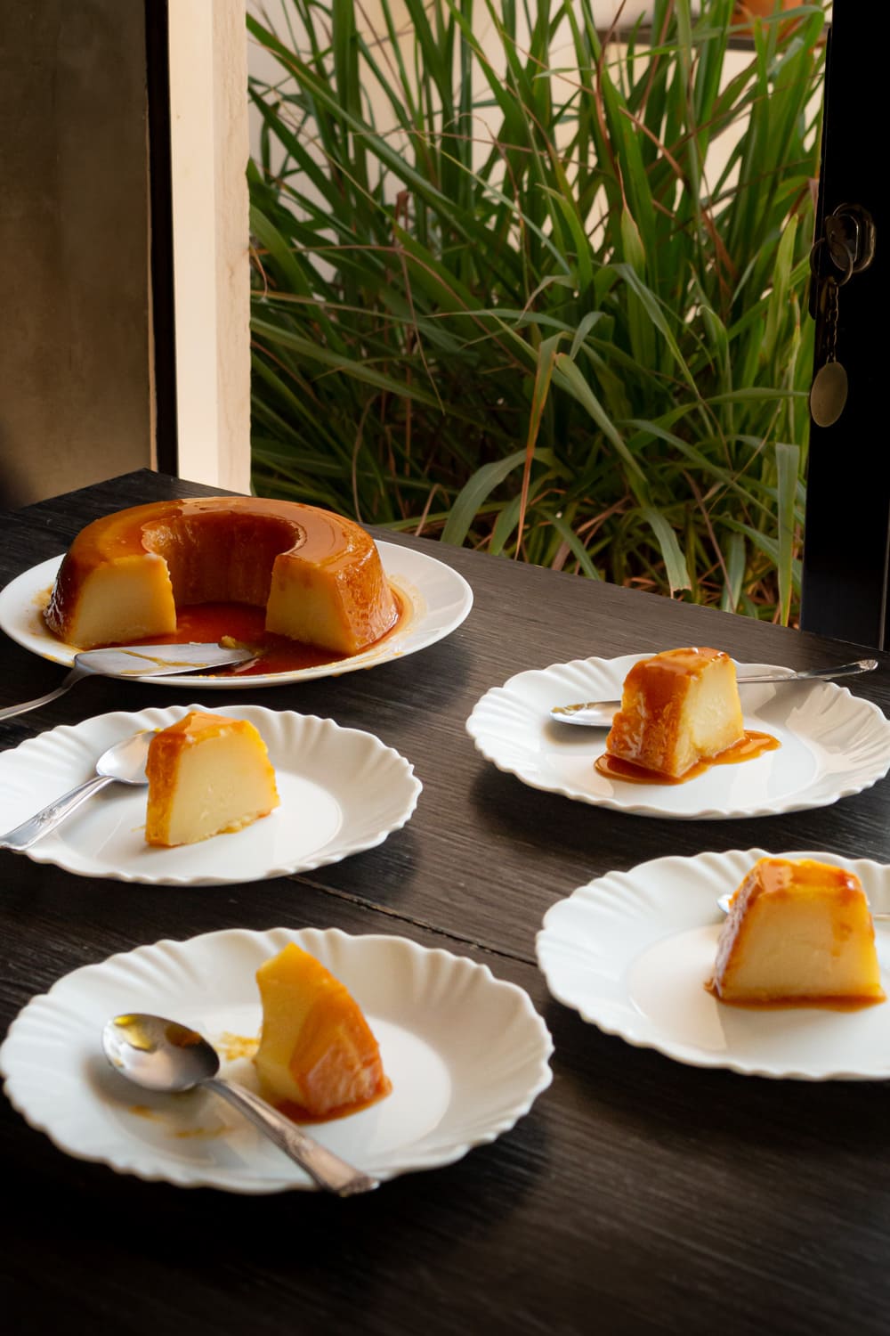 foto de uma mesa de madeira com vários pratinhos branco com pedaços já servidos