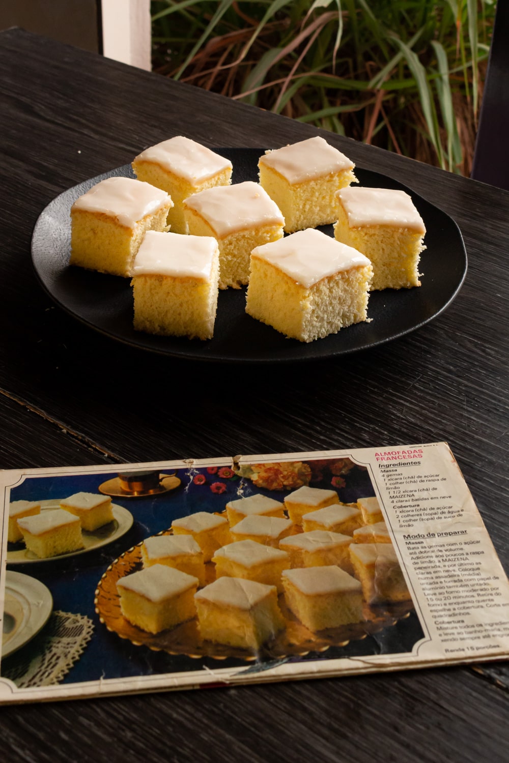 mesa de madeira com um prato com pedaços de bolo e um papel antigo com uma foto de um prato com pedaços de bolo