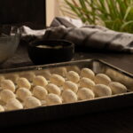 tabuleiro cheio de gnudi cobertos de farinha