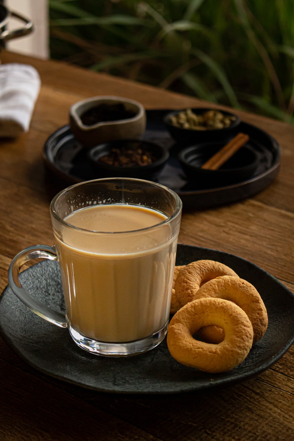 xícara de chai num pratinho com rosquinhas