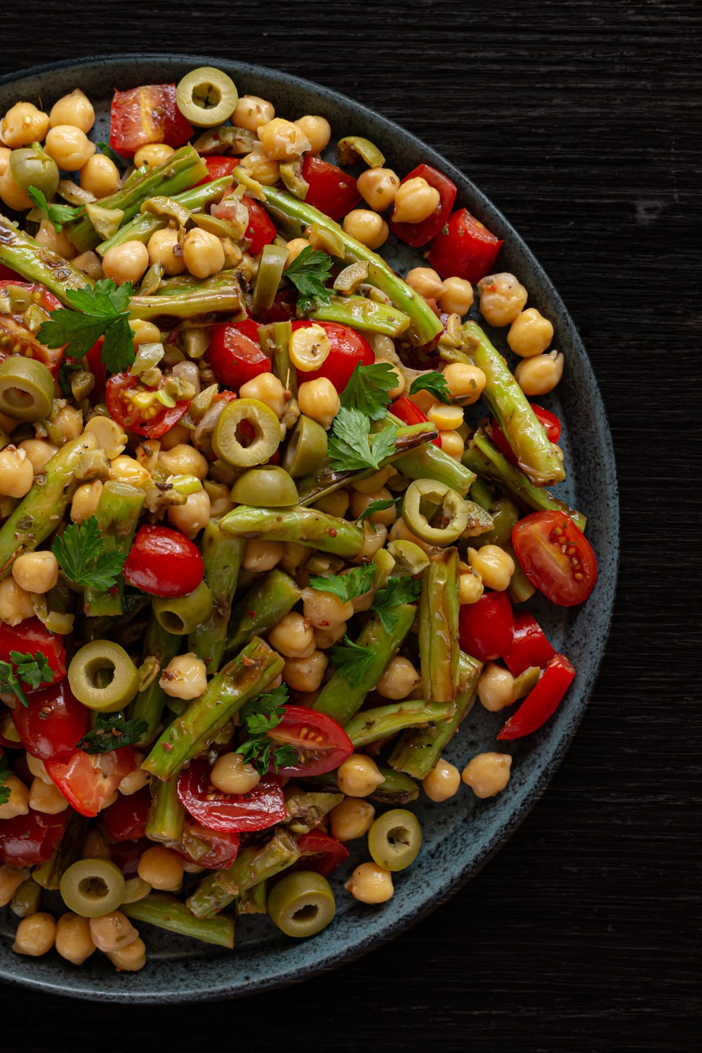 foto do prato com a salada de vagem é possível ver pedaços de vagem, tomate, azeitona, grãos de bico e folhas de salsinha