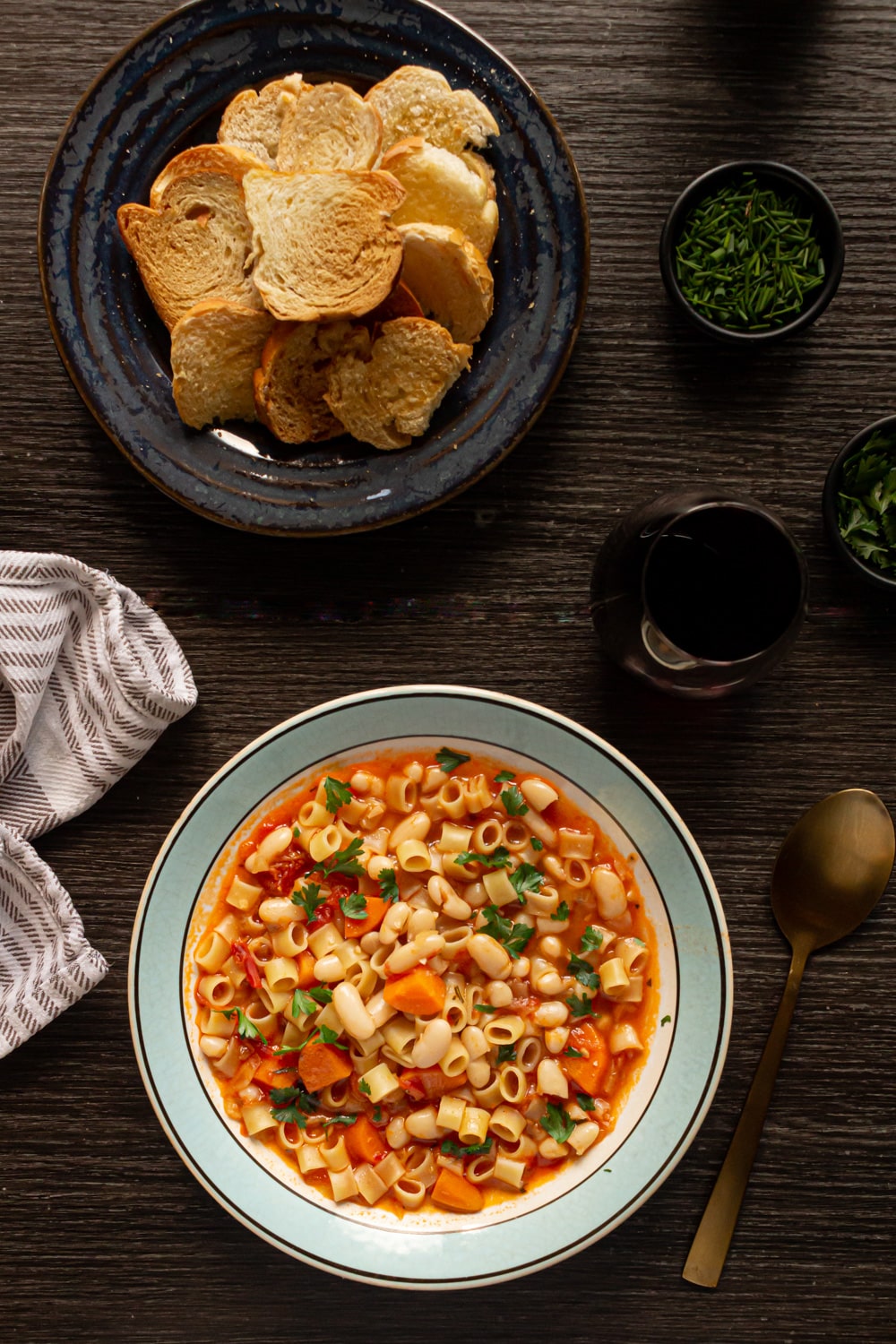 prato de sopa de feijão e macarrão e um pratinho de torradas