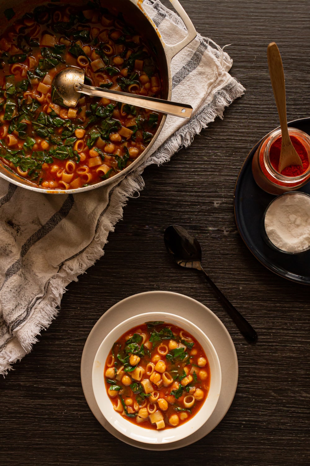 vista aérea da mesa com a tigela servida e o panelão do lado de um pratinho com temperos