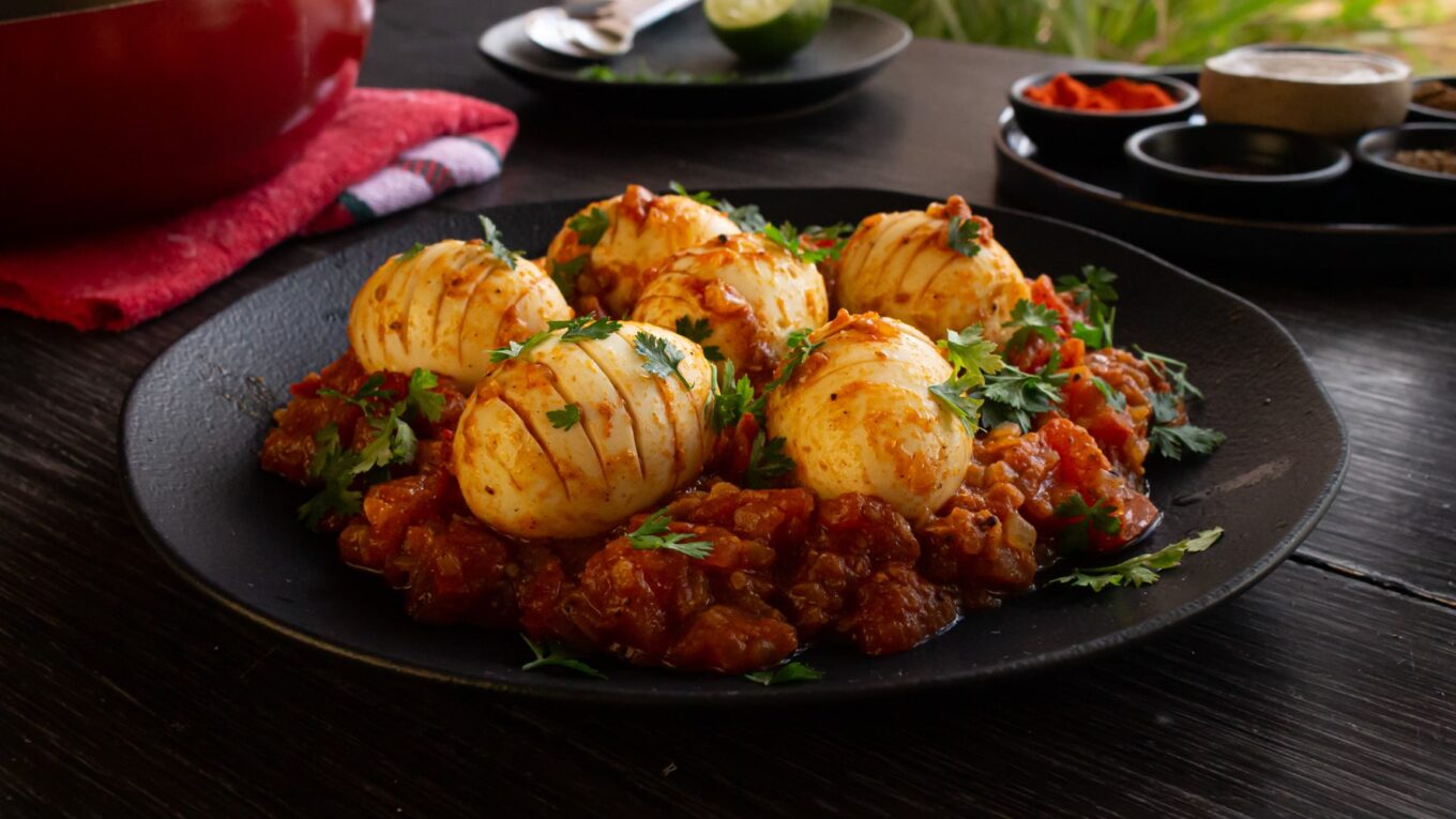 prato de ovos cozidos servido sobre um molho de tomate bem pedaçudo