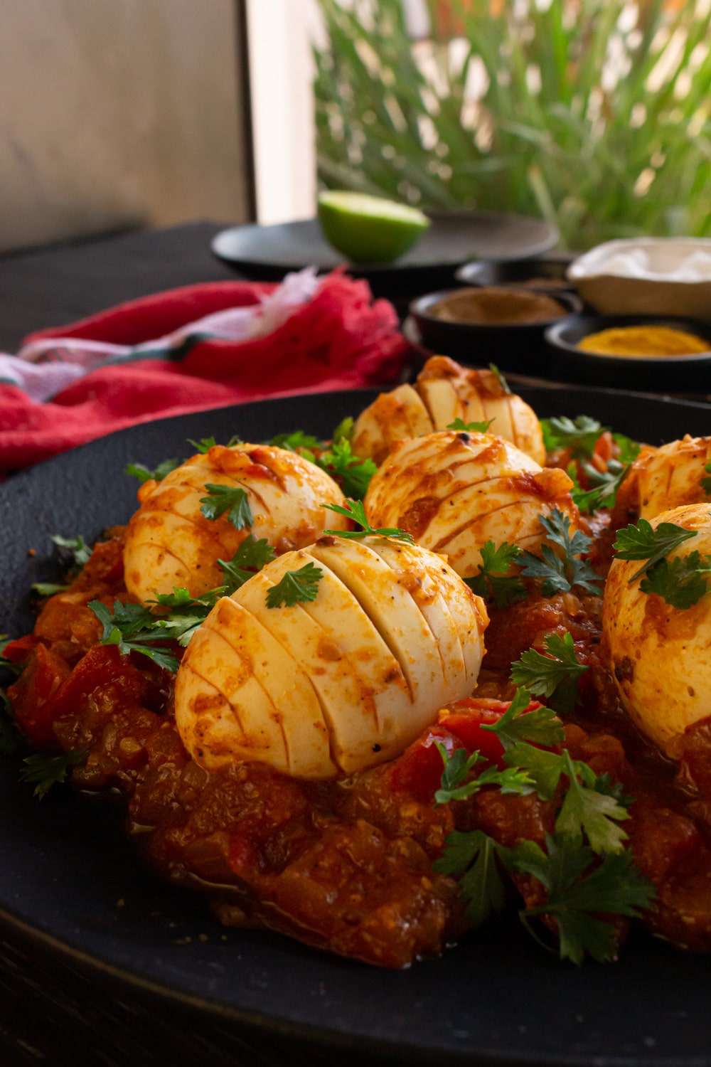 Close do prato com o molho de tomate e os ovos, mostrando bem os cortes em um dos ovos cozidos